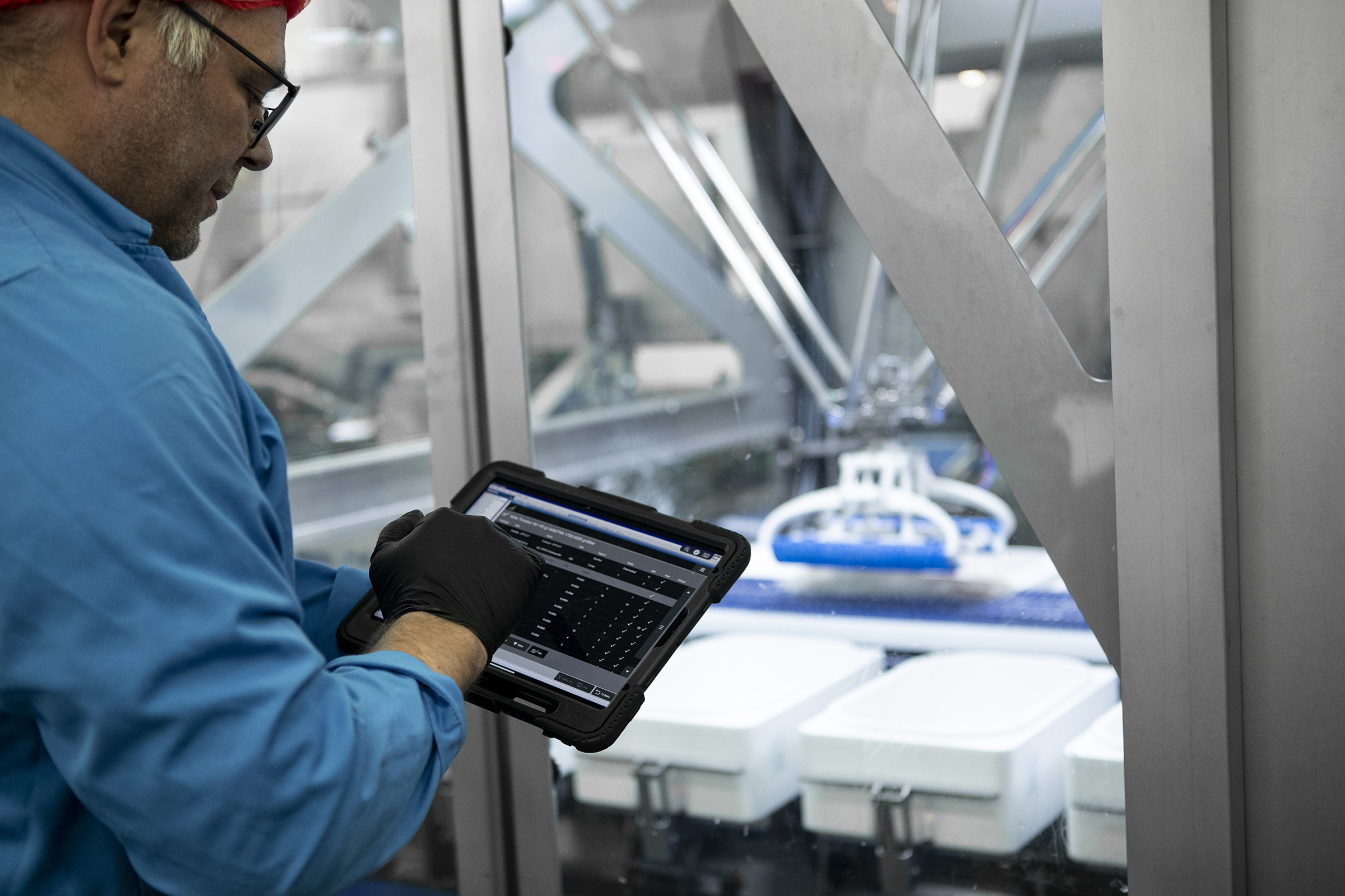 Employee monitoring fish processing line on tablet