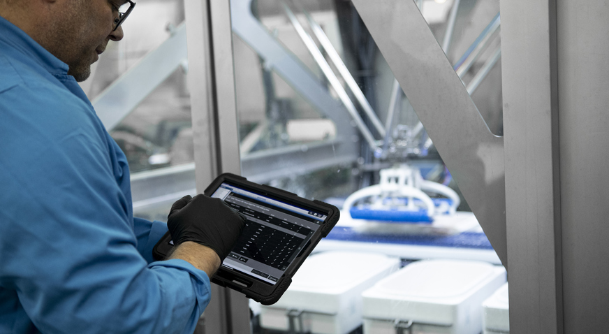 Employee monitoring fish processing line on tablet